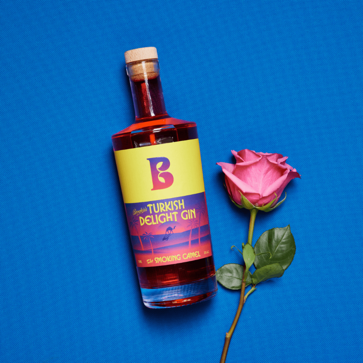 A bottle of pink gin placed beside a delicate rose, creating a charming and elegant composition.
