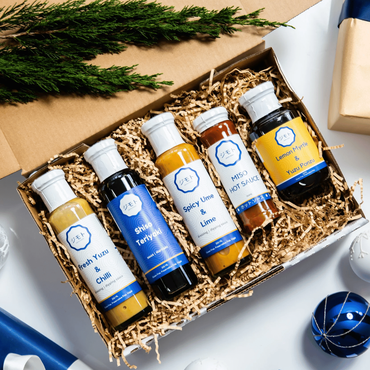A festive gift box with four bottles of delicious sauces, perfect for the holiday season.