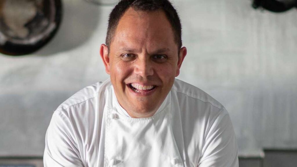 Chef Alastair McLeod in chef whites smiling at the camera.