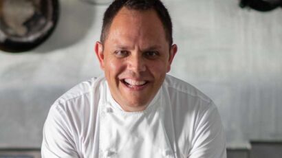 Chef Alastair McLeod in chef whites smiling at the camera.