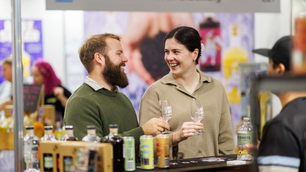 Man and woman smiling at each other while enjoying a tasting at the Good Food & Wine Show