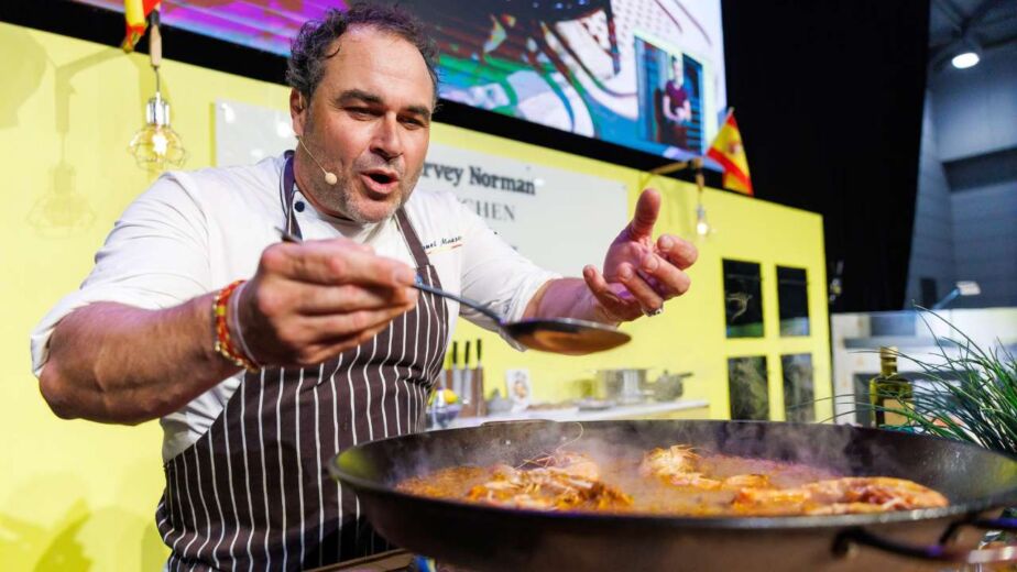 Celebrity chef Miguel Maestre cooking paella on the main stage and smelling the aromatic ingredients at the Good Food & Wine Show.