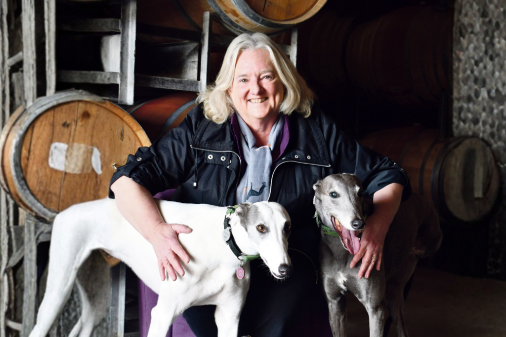 Winemaker Jo Irvine standing outdoors with her two dogs