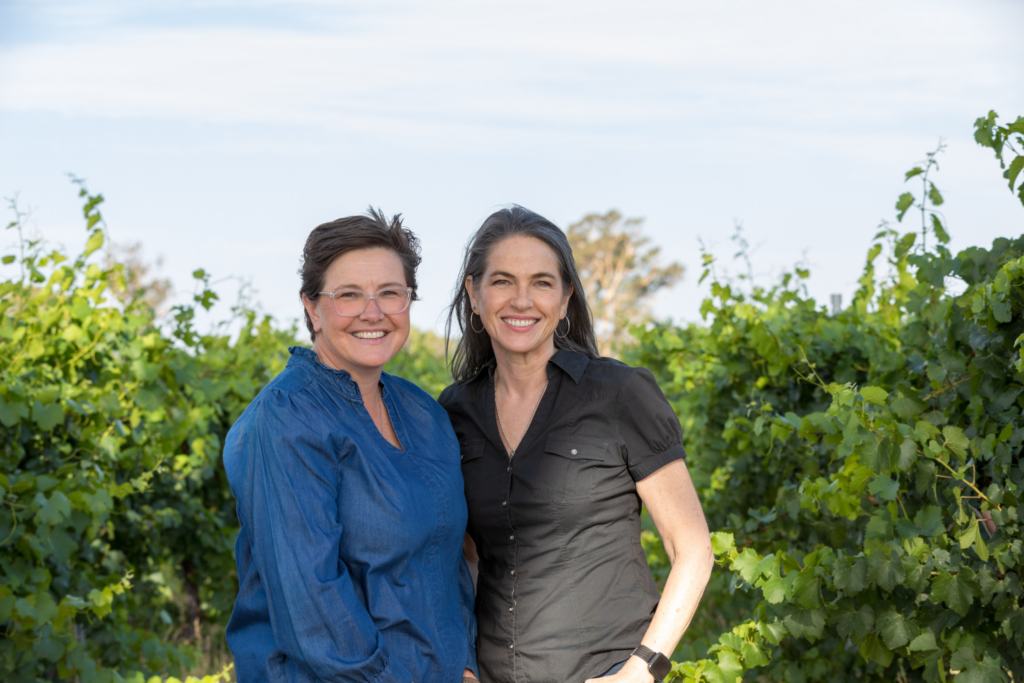 Sisters and winemakers Jane Richards and Claire Davies standing together at their winery