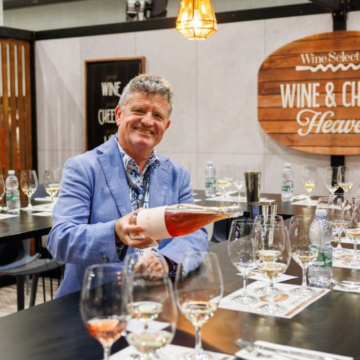 Wine Selectors host pouring rosé into a tasting glass in the Wine Selectors Tasting Room at the Good Food & Wine Show