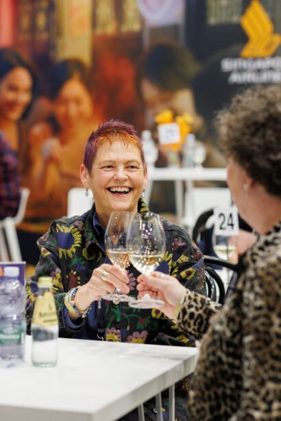 Two women toasting with glasses of wine while enjoying the VIP Lounge at the Good Food & Wine Show in Melbourne.