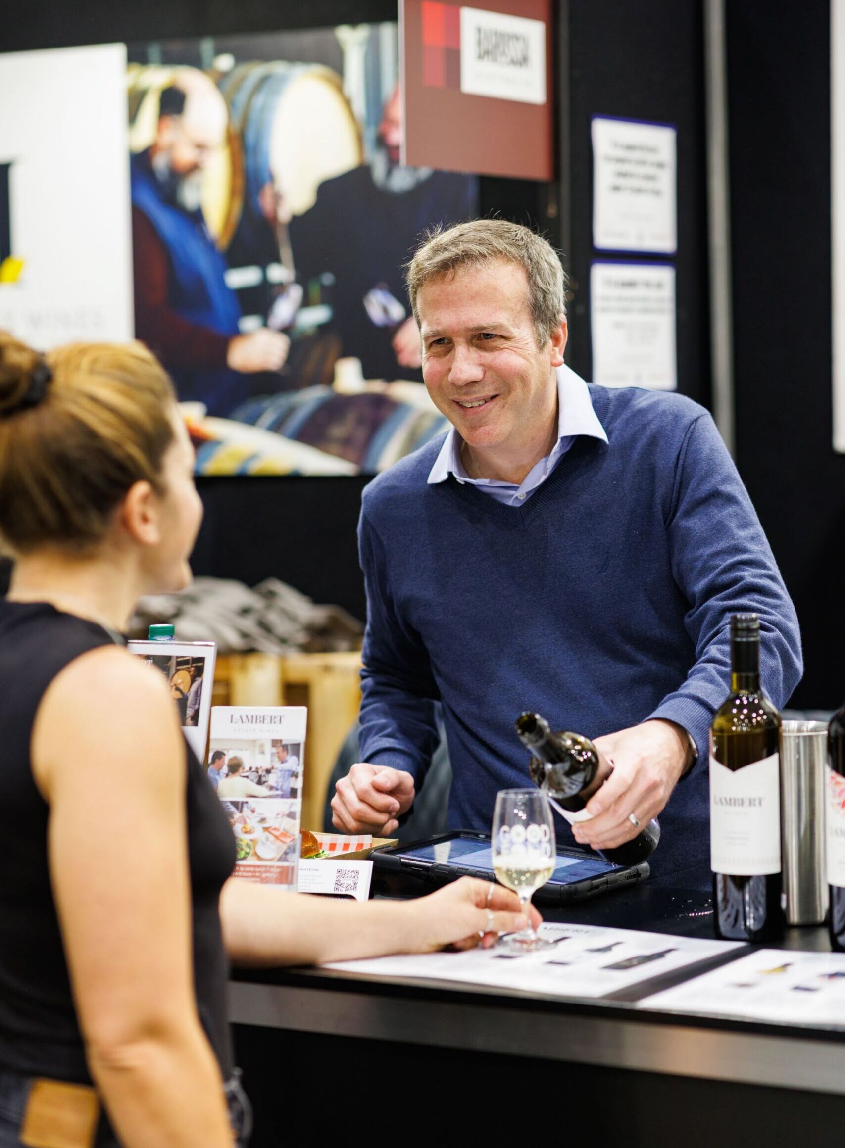 Wine exhibitor pouring a tasting for a guest at the Good Food & Wine Show in Brisbane.