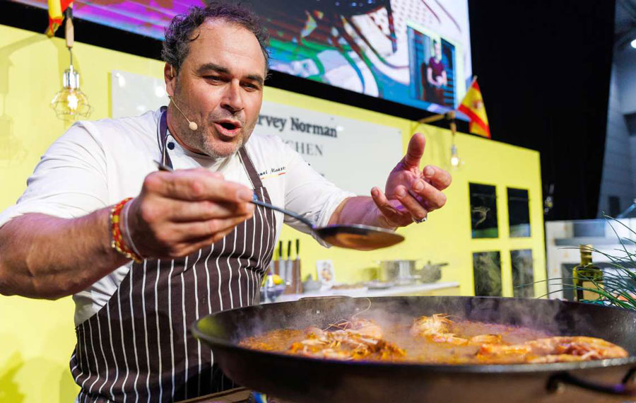Celebrity chef Miguel Maestre cooking paella on the main stage and smelling the aromatic ingredients at the Good Food & Wine Show.