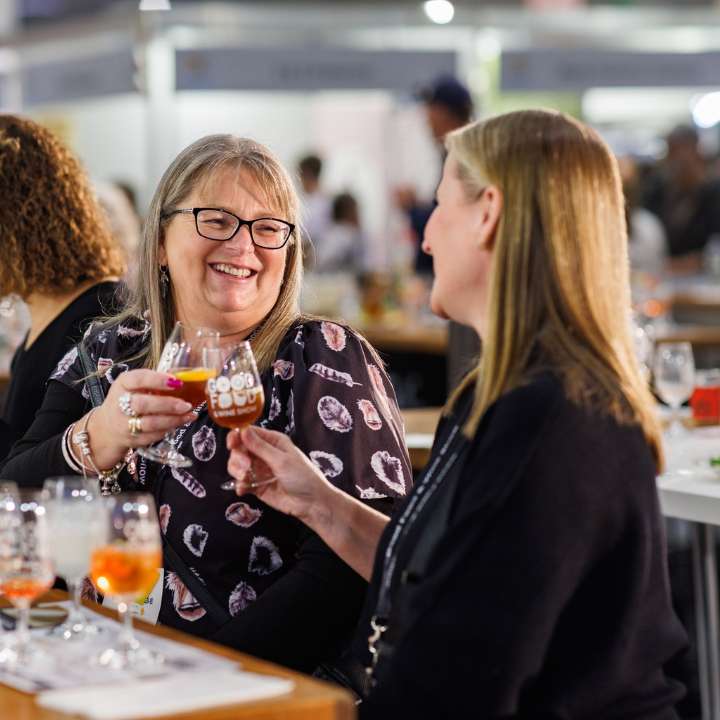 Two women clinking glasses during the Spirit Lover Masterclass at the Good Food & Wine Show.