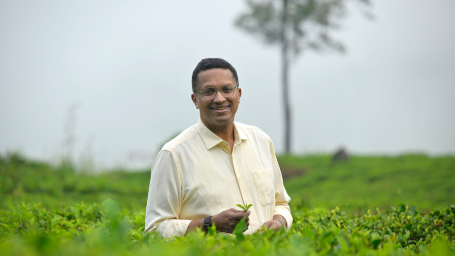 Dilhan C. Fernando, Chairman and CEO of Dilmah Tea, standing in a lush tea plantation in Sri Lanka