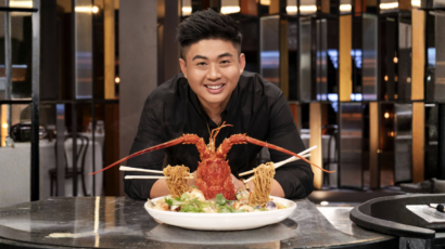 Chef Vincent Yeow Lim leaning over a freshly prepared seafood dish in a restaurant