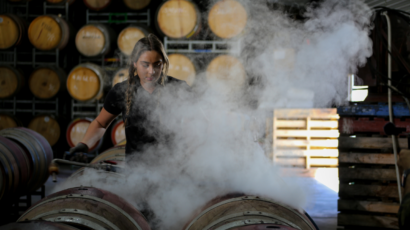 Winemaker Darcy Lapidge from Soul Growers standing over wine barrels in a winery
