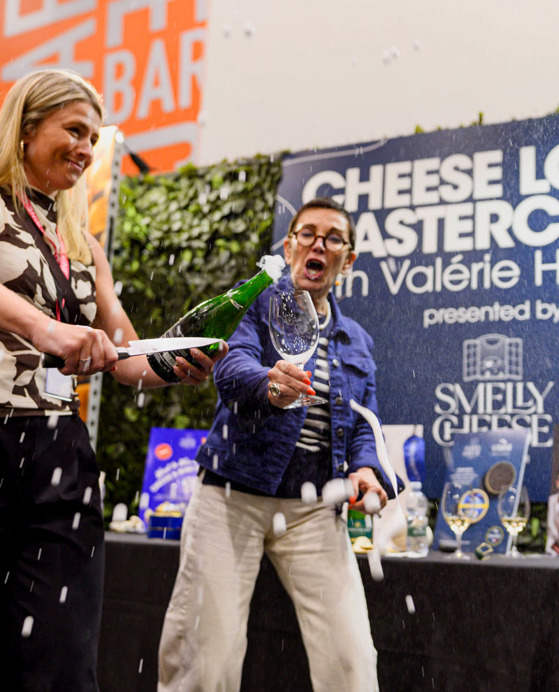 An attendee raises a glass of champagne during the Cheese, Champagne & Caviar Masterclass at the Good Food & Wine Show, enjoying a premium guided tasting experience.