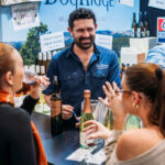 Exhibitor and smile, enjoying talking to visitors experiences at the Good Food & Wine Show.