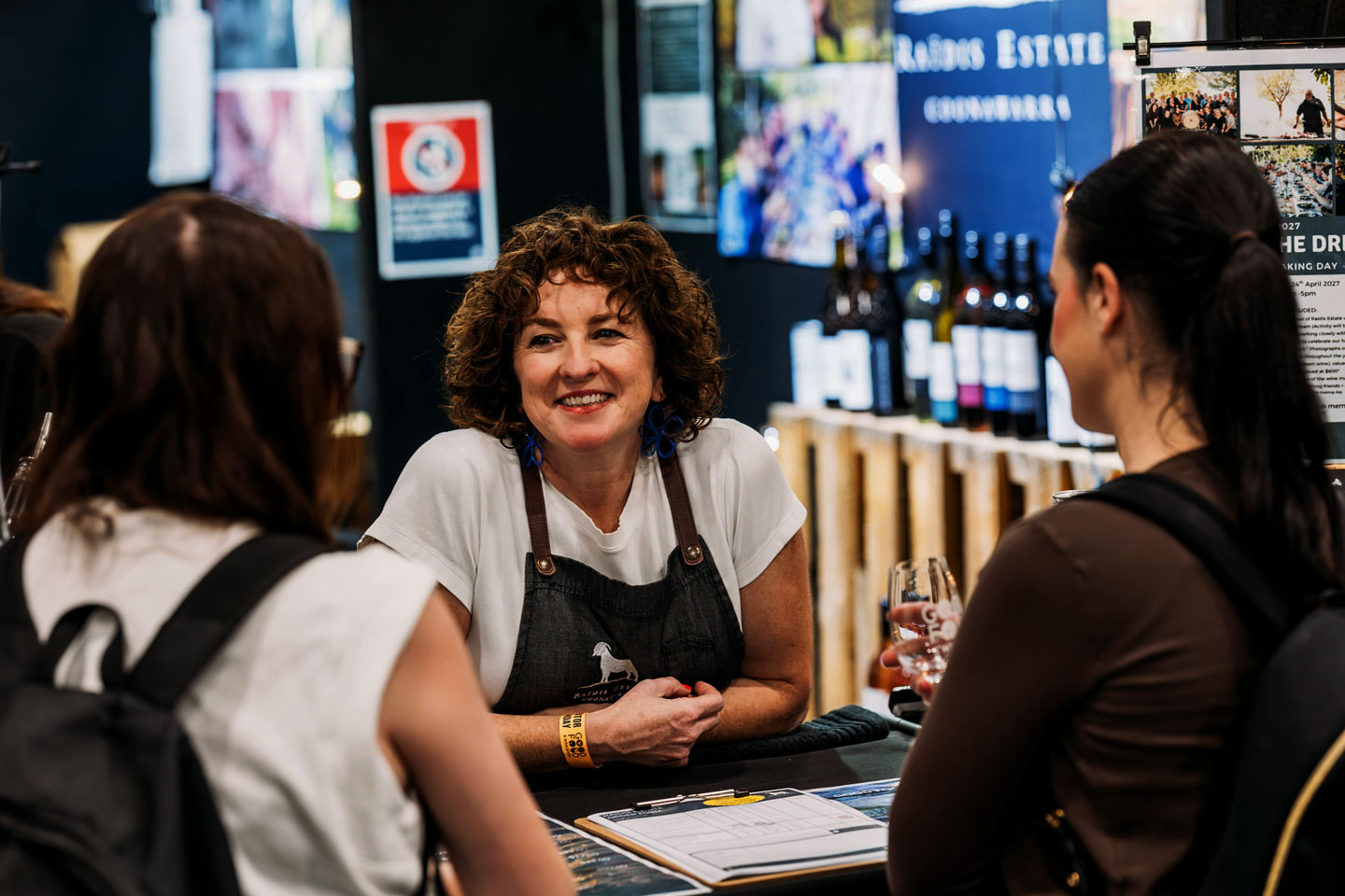 Exhibitor and smile, enjoying talking to visitors experiences at the Good Food & Wine Show.
