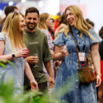 Three visitors raise their glasses and smile, enjoying the tasting experiences at the Good Food & Wine Show.